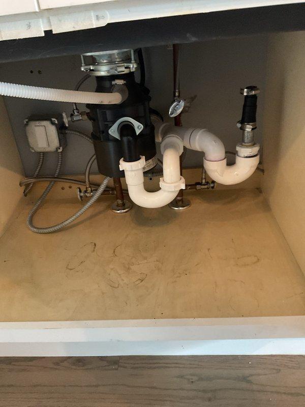 Responded to kitchen sink drainage issue where basin was draining very slowly and only functioning when garbage disposal was activated. Upon inspection, identified obstruction in the drainage system beneath the sink. Cleared blockage from P-trap and drainage pipes, restoring proper water flow through the dark stainless steel sink basin. Verified garbage disposal operation and confirmed all plumbing connections were secure and functioning correctly. System now draining properly without requiring disposal activation.