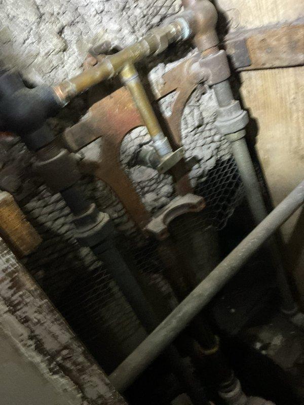 Responded to a bathtub faucet leak in a century-old home where water had been dripping for several weeks. Inspected the wall-mounted three-handle faucet fixture system and associated plumbing connections in the tiled bathroom area. Assessed the aged plumbing infrastructure throughout the property, including examination of basement piping and valve assemblies, to determine the source of the leak and evaluate the overall condition of the water supply system given the home's age and existing wear patterns.