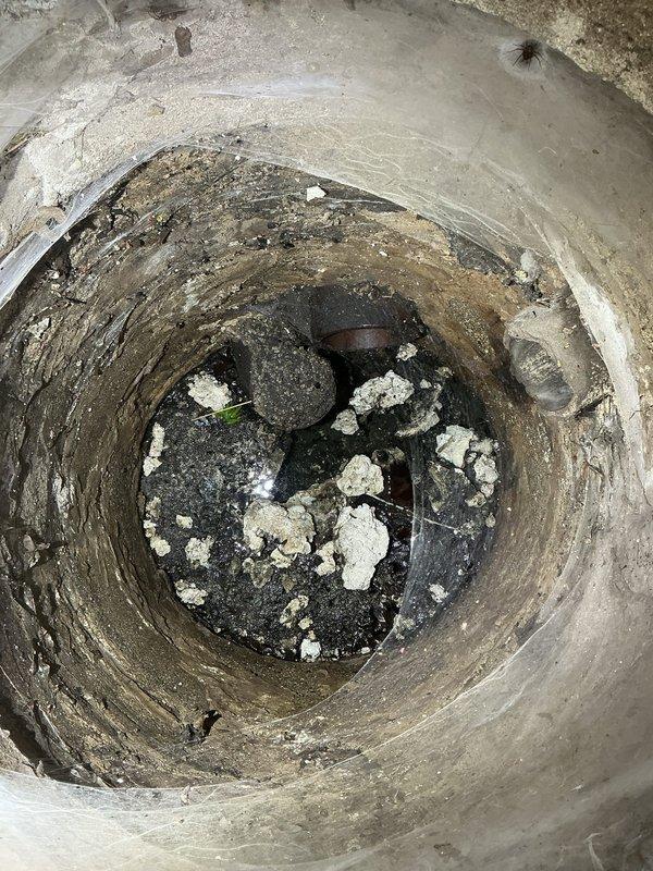 Responded to priority commercial drain and sewer estimate request. Upon arrival, conducted thorough inspection of the facility's plumbing infrastructure, including water heater installation and underground drainage system. Documented existing conditions with detailed photography of gas-fired water heater assembly, including control valve mechanisms, copper and PVC piping connections, and base installation on concrete slab. Performed visual assessment of circular concrete drainage structure, identifying accumulated sediment, debris, and mineral deposits at base level with evidence of moisture infiltration and surface deterioration along interior walls. Provided comprehensive estimate for required drain and sewer work based on observed conditions and system evaluation.