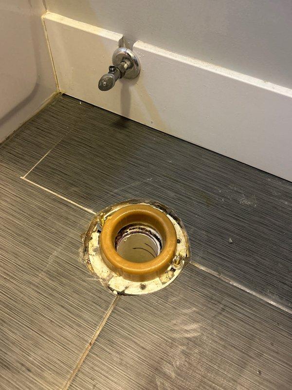 Completed installation of customer-supplied two-piece toilet in bathroom with gray wood-grain tile flooring. Removed existing toilet, prepared flange with new wax ring seal, positioned and secured new toilet unit, and verified proper water supply connection and operation. All fixtures installed according to manufacturer specifications with no leaks detected upon testing.