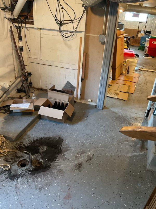 Responded to customer report of water backing up through basement floor drains. Upon arrival, conducted thorough inspection of the drain line system and identified signs of previous water accumulation around the basement floor drain, evidenced by dark staining on the concrete floor surrounding the drain opening. Assessed the drainage system to determine the cause of the backup and evaluated the extent of the issue affecting the basement area. Documented conditions with photographic evidence showing water damage patterns and drain location for further evaluation and recommended course of action.
