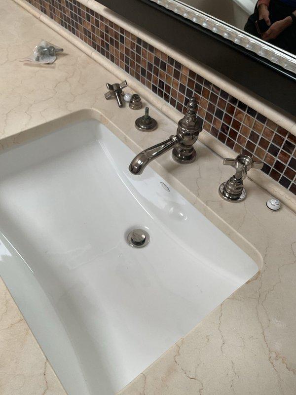 Responded to service call for reduced water flow in multiple fixtures following municipal water main replacement. Debris from street water main work had entered the home's plumbing system, causing blockages and restricted flow to two bathroom sinks, one shower, and one toilet tank fill valve. 

Systematically inspected and serviced all affected fixtures. Removed and cleaned faucet aerators on both bathroom sinks to clear sediment buildup. Disassembled and flushed shower head and valve components to restore proper flow. Accessed toilet tank fill valve, removed debris from inlet screen and valve assembly, and verified proper tank filling operation. Tested all fixtures after cleaning to confirm full water pressure and flow restoration. All fixtures now operating at normal capacity with clear water flow.