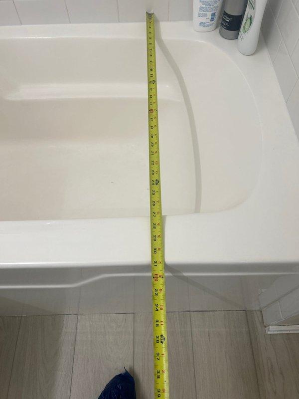 Conducted on-site assessment for bathtub installation in residential bathroom with existing white alcove-style tub and subway tile surround. Performed detailed measurements of the bathtub enclosure dimensions and evaluated existing plumbing fixtures, including chrome shower assembly, tub spout, and drain configuration. Documented current bathroom layout and conditions to provide accurate estimate for new tub installation requirements.