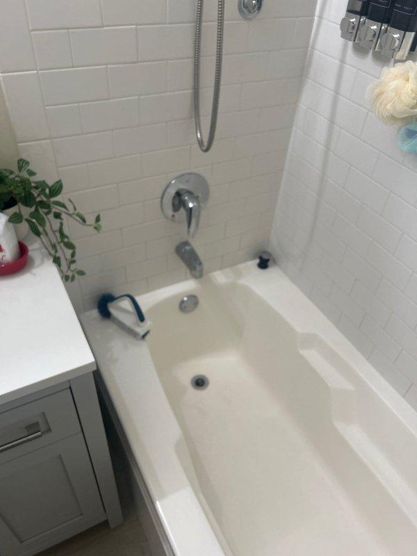 Conducted on-site assessment for bathtub installation in residential bathroom with existing white alcove-style tub and subway tile surround. Performed detailed measurements of the bathtub enclosure dimensions and evaluated existing plumbing fixtures, including chrome shower assembly, tub spout, and drain configuration. Documented current bathroom layout and conditions to provide accurate estimate for new tub installation requirements.