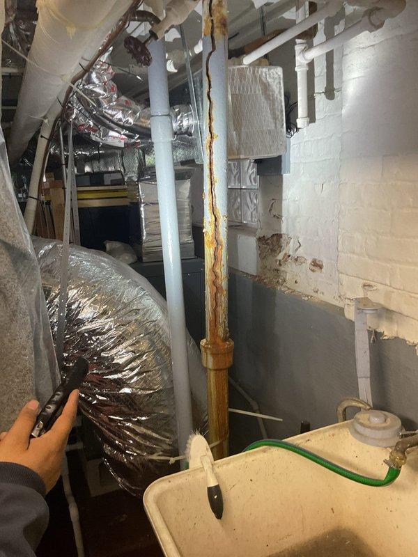 Responded to emergency service call for basement flooding following heavy rainfall due to suspected catch basin blockage. Performed thorough inspection of catch basin and underground drainage system, documenting significant debris accumulation and deterioration of concrete structure. Rodded catch basin to clear blockage and restore proper drainage flow. Additionally addressed utility sink drainage issue in basement, clearing slow drain to restore normal operation. Inspected basement plumbing infrastructure, noting rust staining on vertical PVC drainage pipes and documented overall condition of mechanical room plumbing connections.