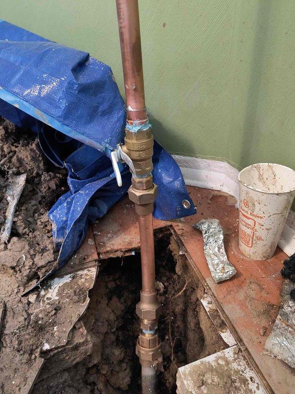 Completed comprehensive plumbing inspection and copper pipe installation through floor penetration. Licensed plumber installed vertical copper pipe assembly with brass fittings, extending from ceiling through new floor opening to subfloor level, with proper insulation applied at ceiling junction. Work area prepared with protective sheeting, floor opening cut and framed for pipe routing, and installation completed per code requirements.