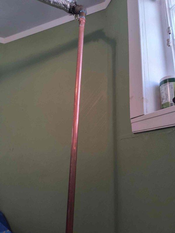 Completed comprehensive plumbing inspection and copper pipe installation through floor penetration. Licensed plumber installed vertical copper pipe assembly with brass fittings, extending from ceiling through new floor opening to subfloor level, with proper insulation applied at ceiling junction. Work area prepared with protective sheeting, floor opening cut and framed for pipe routing, and installation completed per code requirements.
