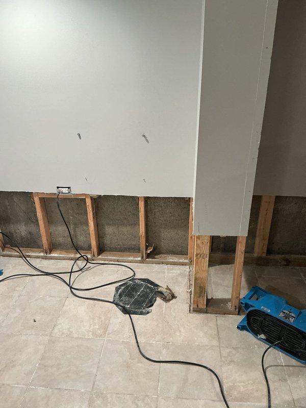 Responded to water damage emergency and deployed comprehensive flood control and moisture mitigation system. Removed compromised drywall sections to expose wall studs and assess extent of water intrusion. Strategically positioned multiple industrial air movers throughout affected rooms to facilitate rapid air circulation and moisture evaporation. Installed commercial-grade dehumidification unit to extract ambient moisture from the air and building materials. Configured proper ventilation and airflow patterns extending through multiple rooms to ensure thorough drying of all impacted areas.