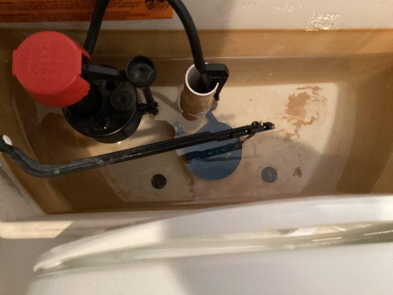 Responded to service call for toilet tank not filling properly with audible slow drip sound in tank. Upon inspection, identified failed fill valve assembly causing inadequate water flow and continuous dripping. Removed toilet tank lid and diagnosed worn internal components within the fill valve mechanism, including deteriorated seals and faulty float adjustment. Shut off water supply at angle stop and drained tank completely. Removed old brass fill valve assembly, which showed significant mineral deposits and corrosion consistent with the 25-year age of the home's plumbing fixtures. Installed new fill valve assembly with adjustable float mechanism and connected refill tube to overflow pipe. Adjusted water level to manufacturer specifications and tested flush cycle multiple times to ensure proper tank refill and shutoff function. Verified no leaks at tank-to-bowl connection and confirmed silent operation with no dripping sounds. Restored water supply and left system fully operational.