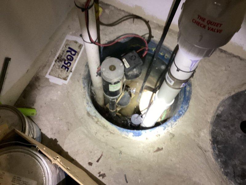 Responded to service call for Duravit in-wall toilet with sticking flush mechanism causing continuous water running. Diagnosed faulty flush actuator components requiring replacement parts and performed inspection of ejector pump system. Verified sump pump installation, check valve operation, and discharge piping assembly for proper functionality during comprehensive basement plumbing system evaluation.