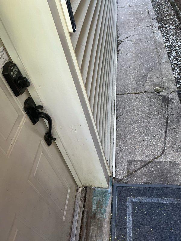 Responded to service call for basement water seepage occurring during rainfall at foundation wall corner and replaced broken bathroom sink drain stopper. Inspected exterior doorway threshold and identified water damage, staining, and potential mold growth at door frame junction, indicating compromised weatherproofing allowing moisture intrusion. Examined interior basement corner where seepage was reported and documented existing conditions. Successfully replaced defective pop-up drain stopper assembly in bathroom sink, restoring proper drainage function.