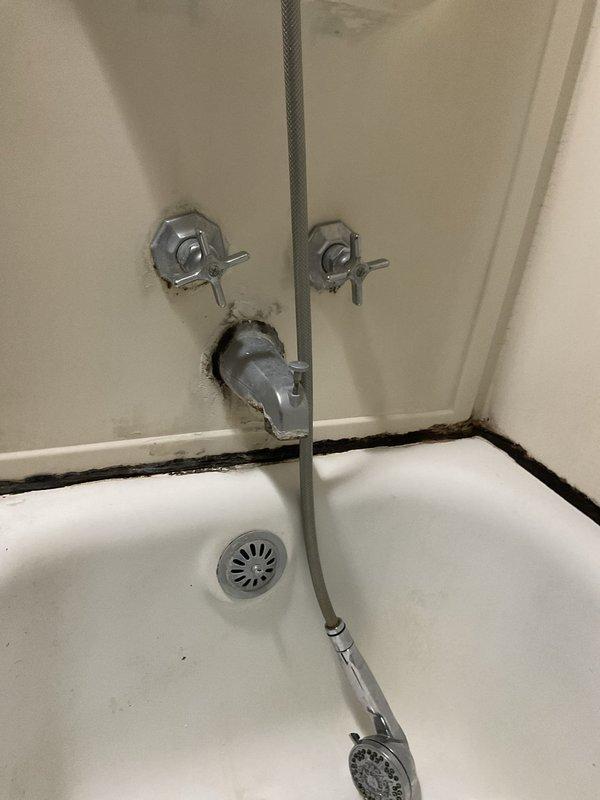 Responded to a leaking double-handle shower faucet in a VIP service call. Replaced both worn cartridges in the wall-mounted cross-handle controls to restore proper water flow and eliminate the leak. The fixtures showed signs of age with visible corrosion and staining around the mounting points, and the repair successfully resolved the reported water leakage issue.