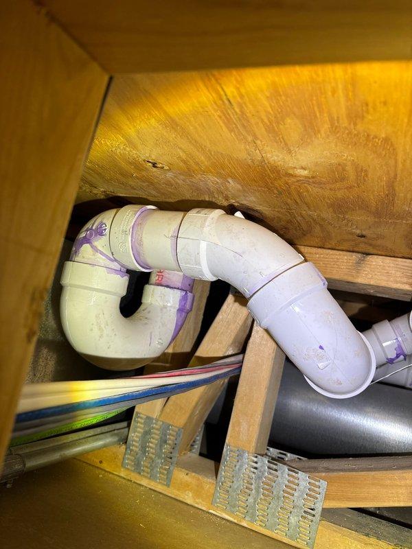 Responded to report of water damage on lower level bedroom ceiling located directly beneath upstairs bathroom. Conducted thorough inspection of plumbing system including crawl space access to examine PVC drain lines and P-trap configuration serving the bathroom fixture above. Documented existing plumbing infrastructure and identified potential leak source in drainage system. Protected work area with plastic sheeting and established containment protocol to prevent further water intrusion during assessment and repair process.
