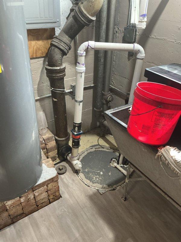 Conducted comprehensive site assessment of residential property to evaluate flood control system installation requirements. Inspected basement utility room containing existing plumbing infrastructure, including cast iron drain lines, PVC piping configuration, and floor drain with metal grate. Evaluated current drainage capacity and identified potential water intrusion points in unfinished mechanical room area with exposed cinderblock walls. Assessed adjacent finished basement recreation space to determine protection requirements for living areas with laminate flooring and finished walls. Documented existing plumbing layout, floor drain location, and structural considerations for flood control system design. Captured detailed photographic documentation of utility room infrastructure and finished basement areas to support system design and equipment specifications. Provided homeowner with professional recommendations for appropriate flood control solutions to protect family home from wat