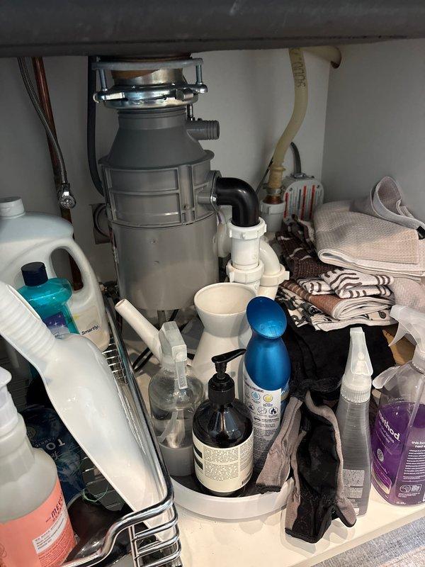 Completed installation of under-sink water filtration system for kitchen fixture. Integrated new filter unit with existing plumbing configuration, which included garbage disposal and PVC drain assembly, ensuring proper water supply connections and secure mounting within cabinet space.