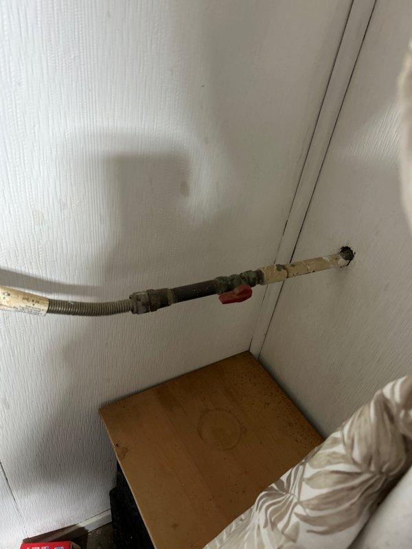 Responded to service request for gas line capping at residential property. Upon arrival, located exposed gas line with deteriorated insulation wrapping along wall near bedroom area. Successfully capped off gas line connection serving previously removed or relocated gas stove, installed appropriate pipe cap fitting, and verified secure seal to prevent gas leakage.