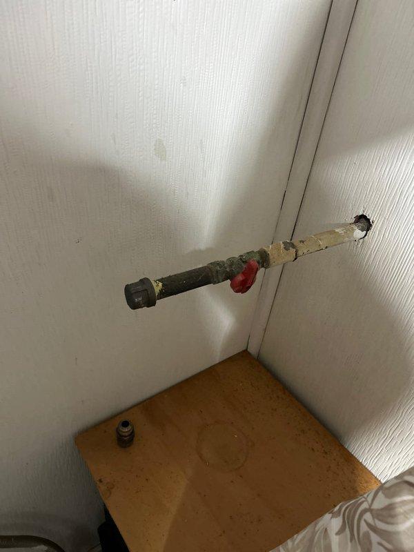 Responded to service request for gas line capping at residential property. Upon arrival, located exposed gas line with deteriorated insulation wrapping along wall near bedroom area. Successfully capped off gas line connection serving previously removed or relocated gas stove, installed appropriate pipe cap fitting, and verified secure seal to prevent gas leakage.