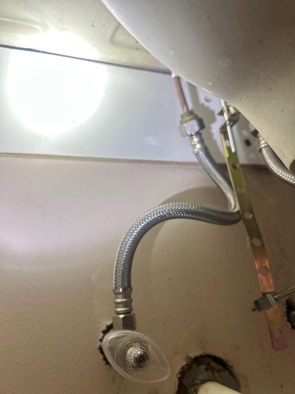 Conducted comprehensive plumbing inspection of residential bathroom vanity and sink assembly. Documented existing fixture conditions including chrome single-handle faucet with pull-out sprayer, white integrated vanity basin, and associated supply line connections. Inspected undersink plumbing components including braided stainless steel flexible supply lines, copper piping, faucet mounting hardware, and drain assembly for potential issues or required maintenance.