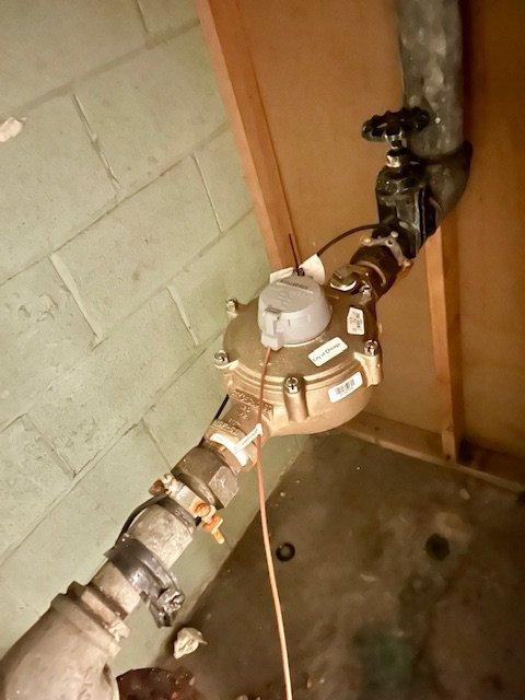 Provided estimate for replacement of aging 3-inch galvanized building water main serving 26-unit commercial property. Scope includes shutting off and draining entire system via existing butterfly valve, removing vertical galvanized waterline using large pipe wrenches, and installing new 3-inch ball valve with drain-down capability as main building shutoff. Work requires potential drywall removal for proper access to 1.5-inch water meter connections, installation of new copper piping to relocate exterior hose bib to front of building within water meter closet area, core drilling through brick wall, and installing new hose bib with dedicated isolation valve for winterization. Upon completion, system will be gradually pressurized and tested to verify proper operation throughout building. Lifetime workmanship warranty provided on all installed components.