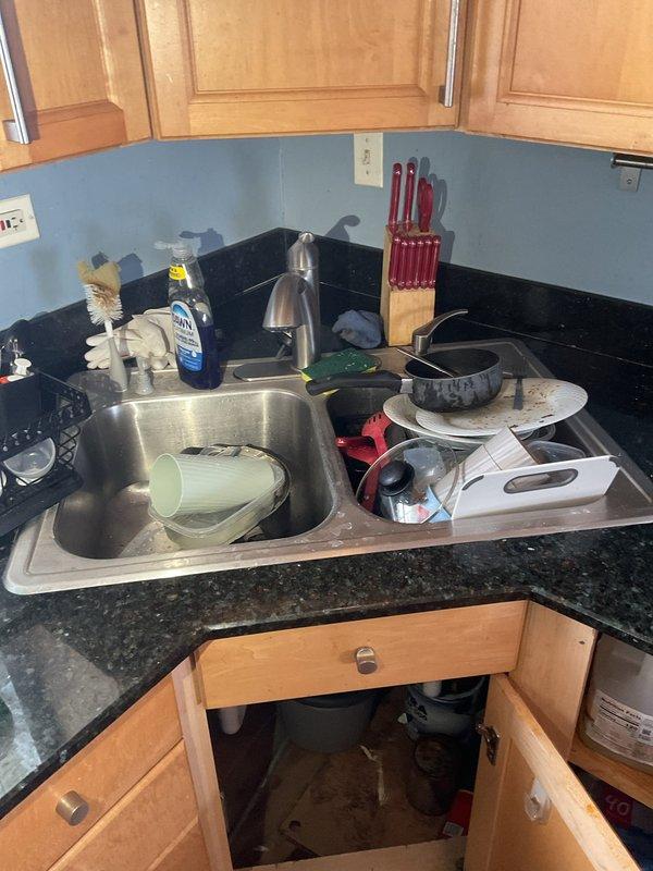 Responded to water leak complaint originating from kitchen sink and affecting the unit below. Conducted visual inspection of kitchen sink area and under-sink plumbing configuration, documenting conditions with photos. Advised that access to both the upper unit (source) and lower unit (affected area) would be required to complete thorough leak investigation and determine exact source of water intrusion. Awaiting confirmation of access to lower unit before proceeding with comprehensive leak location service and necessary repairs.