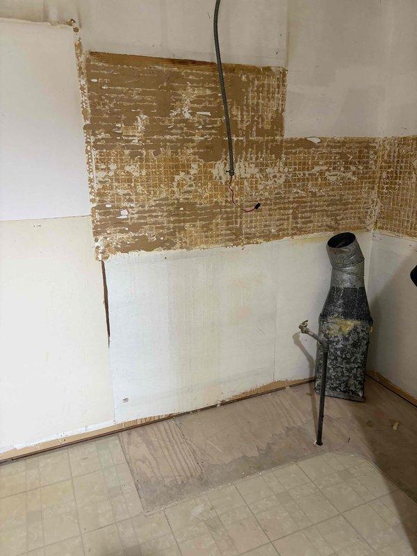 Conducted plumbing estimate for kitchen piping replacement in 60-year-old residential property. Assessed multiple exposed metal pipes protruding from deteriorated wall surfaces, noting corrosion and aging of existing plumbing fixtures. Documented condition of obsolete piping system requiring replacement due to age-related deterioration consistent with original home construction.