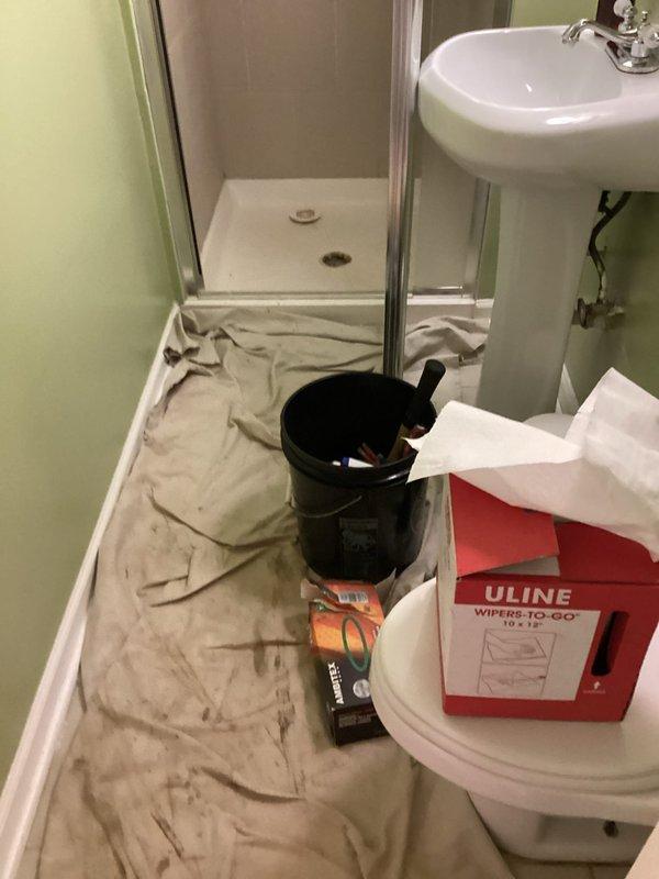 Completed plumbing repair involving PVC drain line installation in ceiling cavity above bathroom. Replaced damaged drainage piping with new white PVC elbows and connectors, applied proper purple primer and solvent cement to all joints per code requirements. Protected bathroom floor with drop cloths during overhead work, maintained clean work area throughout service call.