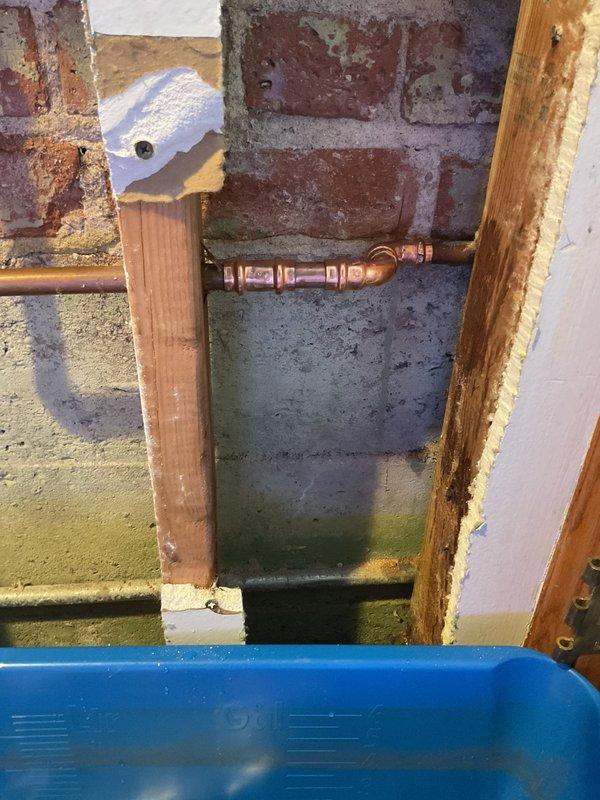 Responded to emergency call for active leak from burst pipe supplying outdoor water spigot. Accessed affected piping through interior wall by creating access openings in drywall, exposing brick masonry and compromised copper supply line. Isolated and replaced damaged section of copper piping with new copper pipe and fittings. Installed temporary collection system to manage water during repair. Insulated exposed piping to prevent future freeze damage. Tested system for proper flow and verified no additional leaks present. Wall access points left open for customer inspection and future closure.