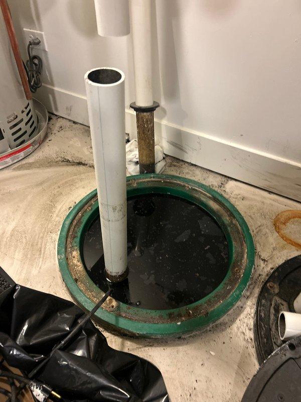 Completed commercial drain and sewer estimate for sump pump system replacement. Inspected existing dual-pipe sump basin installation showing severe corrosion on metal components, deteriorated green-painted rim, and compromised structural integrity. Assessed current configuration featuring white PVC discharge pipe alongside heavily corroded metal pipe, evaluated pumping capacity requirements, and provided comprehensive estimate for complete system upgrade including new basin, dual pump installation, check valves, and proper electrical connections to meet commercial building codes.