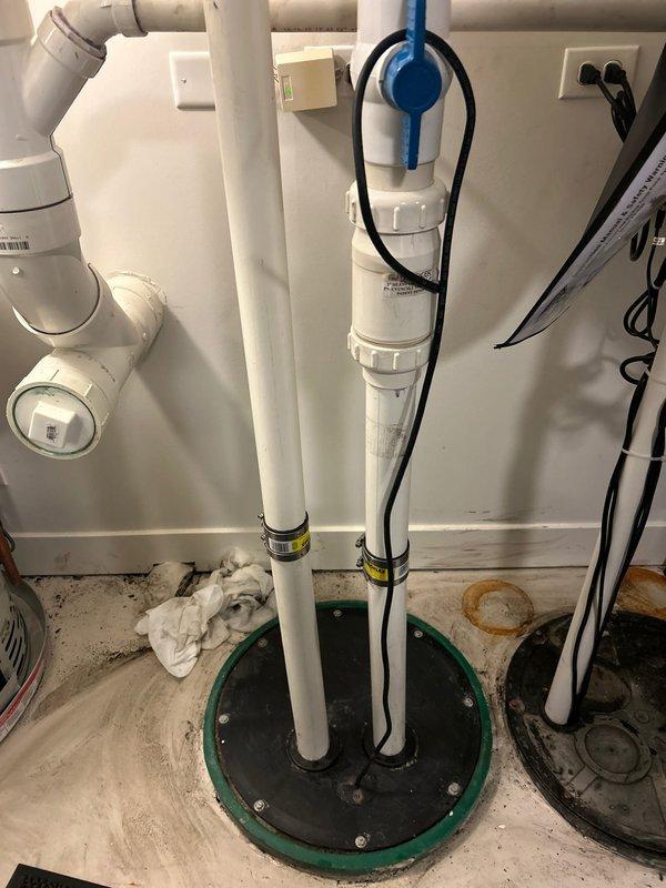 Completed commercial drain and sewer estimate for sump pump system replacement. Inspected existing dual-pipe sump basin installation showing severe corrosion on metal components, deteriorated green-painted rim, and compromised structural integrity. Assessed current configuration featuring white PVC discharge pipe alongside heavily corroded metal pipe, evaluated pumping capacity requirements, and provided comprehensive estimate for complete system upgrade including new basin, dual pump installation, check valves, and proper electrical connections to meet commercial building codes.