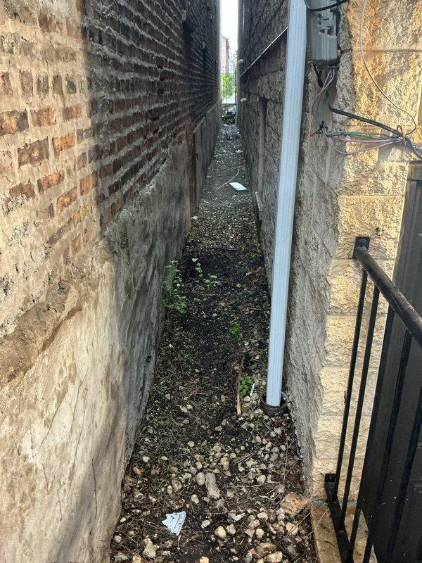 Responded to clogged drain service call at commercial property. Upon arrival, accessed drainage system through exterior service alley between buildings. Inspection revealed significant blockage in main drain line caused by accumulated fibrous debris and organic material obstruction. Utilized professional drain cleaning equipment to clear blockage and restore proper water flow through the affected pipe system. Verified complete drainage functionality upon completion and documented conditions with photographic evidence.