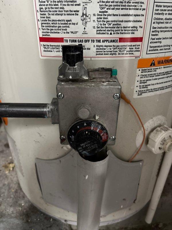 Responded to gas leak detected by utility company at water heater gas valve connection. Inspected gas control assembly, valve connections, and supply piping. Documented existing water heater installation and gas control components for warranty service verification.