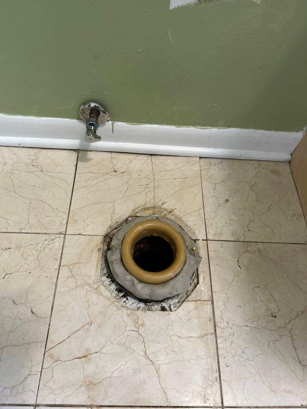 Completed building water shutdown to facilitate plumbing repairs in bathroom facility. Addressed deteriorated floor drain with compromised grout and surrounding tile damage, replaced corroded drain components and resealed perimeter to prevent water infiltration. Serviced toilet supply line connections and shut-off valve to ensure proper operation following building water restoration.
