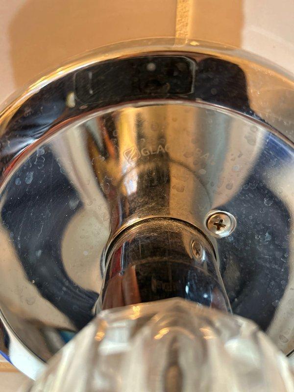 Responded to service call for shower cartridge replacement in tub/shower combination unit. Upon arrival, accessed plumbing valve assembly through existing wall access opening to assess cartridge compatibility. Customer had previously removed original faucet and handle, and provided replacement Glacier Bay shower handle and tub faucet components with uncertainty about proper fitment. Inspected brass valve body and threaded connections behind wall-mounted access panel to verify cartridge specifications and compatibility with customer-supplied fixtures. Evaluated existing plumbing configuration including shower arm, escutcheon plate, and valve assembly condition. Confirmed proper installation requirements and provided assessment of replacement parts compatibility with existing rough-in valve system.