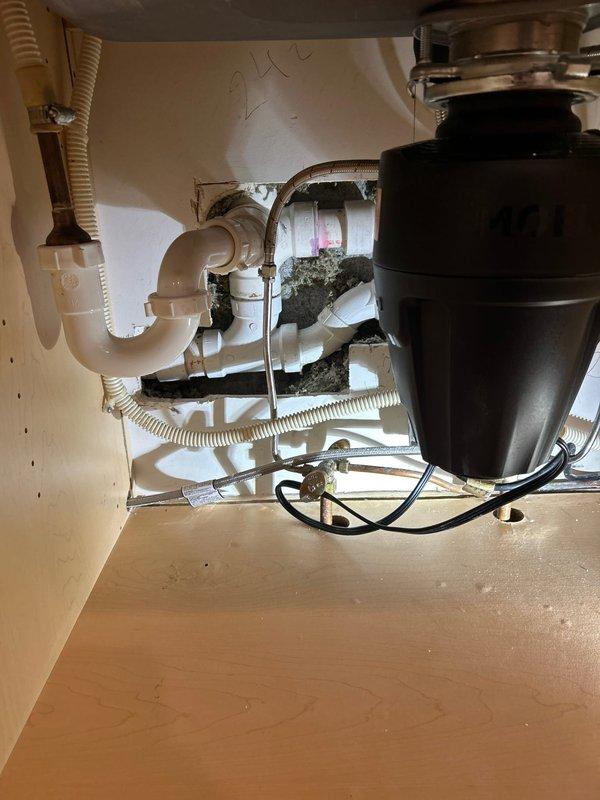 Responded to kitchen sink leak caused by improperly installed P-trap assembly. Upon inspection, found the P-trap connections beneath the sink were not properly secured, resulting in active water leakage. Disassembled the existing trap configuration, cleaned all connection points of accumulated debris and buildup, and reinstalled the P-trap with proper alignment and secure fittings. Verified all connections between the garbage disposal unit and drain system were tight and leak-free. Tested the system by running water through the sink and disposal to confirm proper drainage and no further leakage.