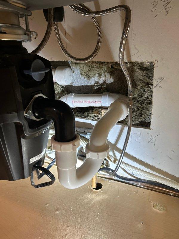 Responded to kitchen sink leak caused by improperly installed P-trap assembly. Upon inspection, found the P-trap connections beneath the sink were not properly secured, resulting in active water leakage. Disassembled the existing trap configuration, cleaned all connection points of accumulated debris and buildup, and reinstalled the P-trap with proper alignment and secure fittings. Verified all connections between the garbage disposal unit and drain system were tight and leak-free. Tested the system by running water through the sink and disposal to confirm proper drainage and no further leakage.