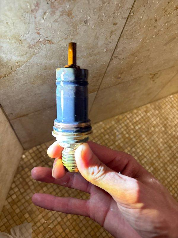 Responded to a low water pressure complaint in an interior shower system. Upon inspection, identified a failing shower mixer cartridge as the source of reduced flow. Replaced the defective cartridge to restore proper water pressure and functionality to the multi-head shower system.