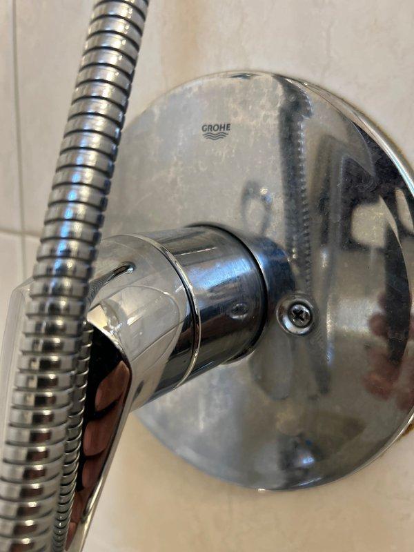 Serviced and inspected Grohe shower valve assembly and handheld shower system in residential bathroom. Addressed water spots and mineral deposits on chrome fixtures, ensuring proper operation of single-lever control valve and sliding rail mechanism. Verified functionality of diverter valve and confirmed all components were properly mounted and operating within manufacturer specifications.