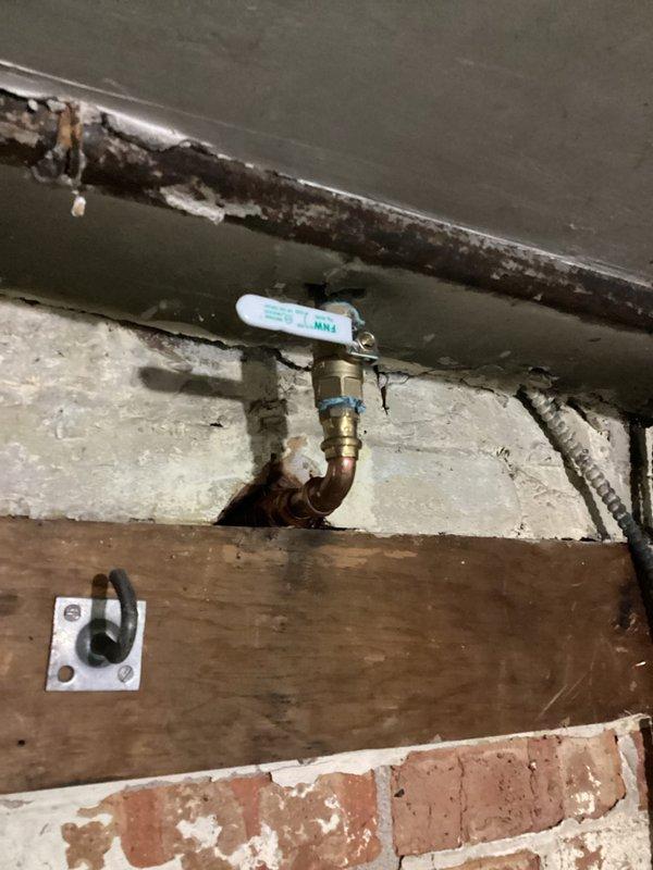 Responded to emergency plumbing call for water leak at previously installed basement shut-off valve. Upon arrival, found active water discharge from ball valve assembly that was installed two years prior. Inspected copper piping and brass valve connections for signs of failure, deterioration, or mechanical damage. Identified source of leak and performed necessary repairs to restore proper valve function and eliminate water intrusion. Verified all connections were secure and tested valve operation to ensure complete shutoff capability. Confirmed no additional water discharge and left system in proper working order.