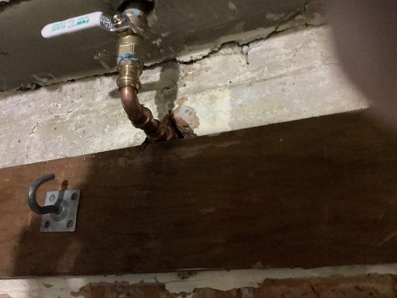 Responded to emergency plumbing call for water leak at previously installed basement shut-off valve. Upon arrival, found active water discharge from ball valve assembly that was installed two years prior. Inspected copper piping and brass valve connections for signs of failure, deterioration, or mechanical damage. Identified source of leak and performed necessary repairs to restore proper valve function and eliminate water intrusion. Verified all connections were secure and tested valve operation to ensure complete shutoff capability. Confirmed no additional water discharge and left system in proper working order.