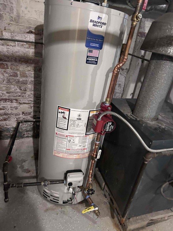 Installed a new 50-gallon Bradford White atmospheric vent gas water heater to replace the existing failed unit. Removed and properly disposed of the old water heater. Installation included a complete new brass pack with fresh supply connections, temperature and pressure relief valve, and all necessary fittings. Connected copper supply lines with proper shut-off valves, installed a recirculation pump on the hot water line, and secured flexible gas connector at the base of the unit. Positioned unit in drain pan for secondary leak protection and verified proper venting configuration with T-shaped flue connector at top of tank. Tested all connections for leaks, confirmed proper gas combustion, and verified hot water delivery throughout the system.