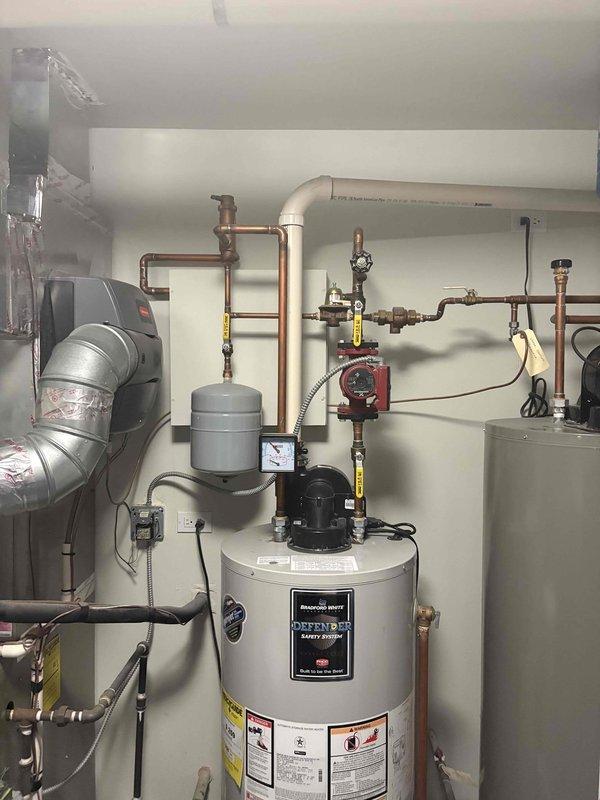 Conducted assessment of dual water heater system serving residential hot water and radiant heating applications. Primary Bradford White Defender unit exhibited short cycling, error code display, and flashing indicators. Both water heaters approximately 11 years old and approaching end of service life. Documented existing mechanical room configuration including circulation pumps, expansion tanks, pressure relief systems, copper supply and return piping, and integrated booster pump assembly. Customer requesting replacement of both units with electric water heaters and exploring tankless options for improved efficiency and space optimization.