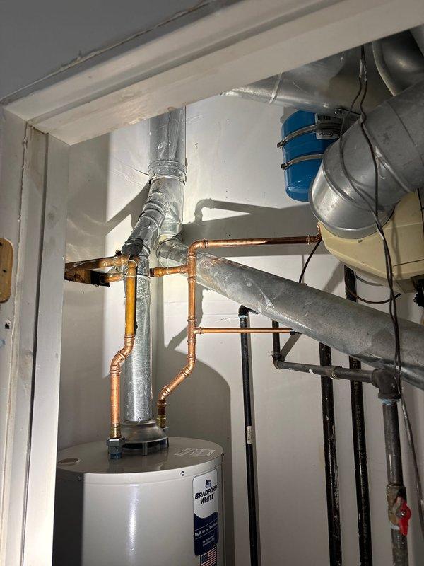 Reinstalled residential water heater in utility room that had been previously removed. Connected all copper supply and discharge piping with proper fittings and joints. Secured unit in place and verified all plumbing connections for proper operation and leak-free performance.