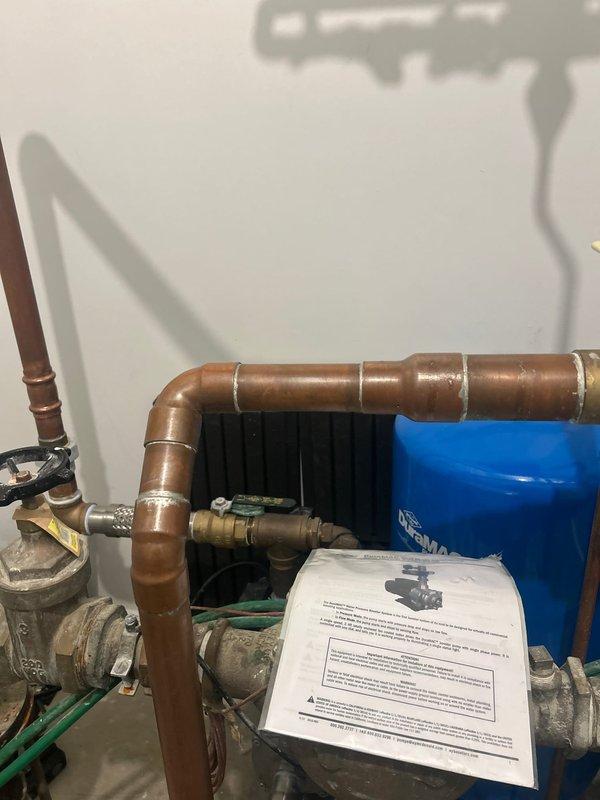 Responded to service call for malfunctioning booster pump system exhibiting rattling noise and pressurizing beyond setpoint. Upon inspection of the copper piping assembly and blue pressure tank installation, isolated and disconnected the pump from power source to prevent further operation. System requires follow-up diagnostics to assess pump functionality, check valve operation, and pressure control issues, with technical support consultation scheduled to determine necessary repairs.