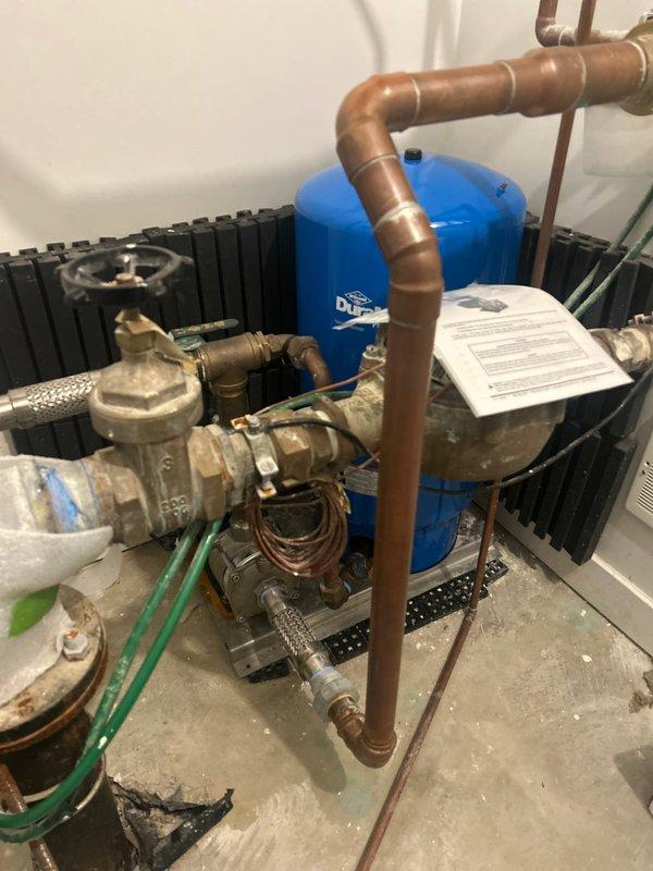 Responded to service call for malfunctioning booster pump system exhibiting rattling noise and pressurizing beyond setpoint. Upon inspection of the copper piping assembly and blue pressure tank installation, isolated and disconnected the pump from power source to prevent further operation. System requires follow-up diagnostics to assess pump functionality, check valve operation, and pressure control issues, with technical support consultation scheduled to determine necessary repairs.