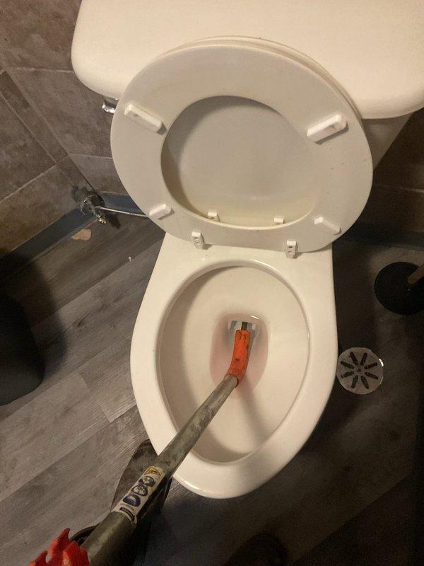 Responded to commercial facility for clogged toilet obstruction. Upon arrival, assessed the fixture and deployed plumbing snake with appropriate tooling to clear the blockage in the drain line. Successfully removed obstruction and restored proper drainage and flushing function to the toilet. Documentation photos captured before and after completion of work.