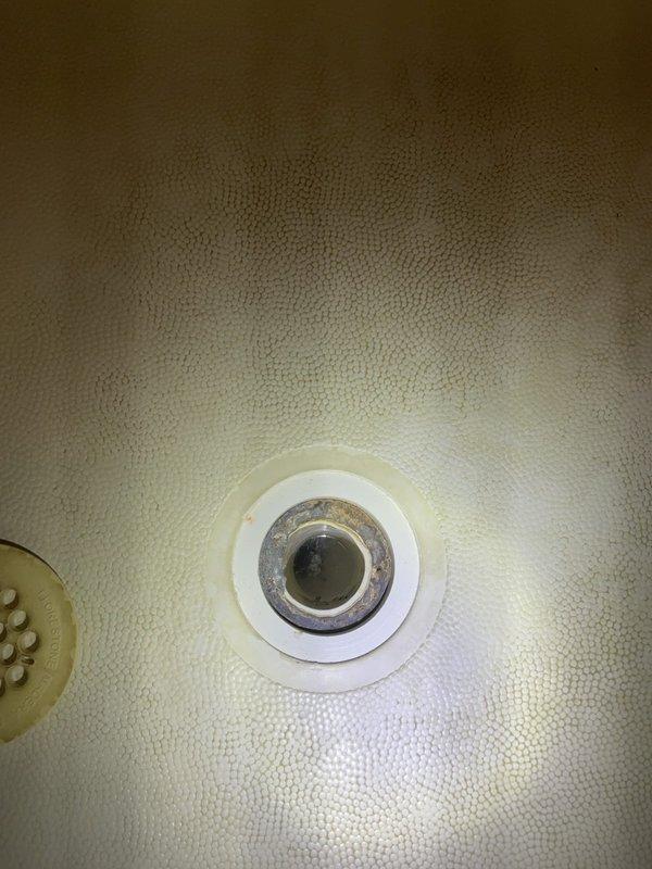 Responded to water leak complaint affecting unit below from shower area. Performed visual inspection of shower basin and drain assembly to locate source of leak. Examined bathtub drain components including metallic drain assembly and surrounding basin for signs of deterioration, improper sealing, or compromised waterproofing. Inspected accessible ceiling area below shower for evidence of water intrusion and damage patterns. Documented conditions with photographs for diagnostic purposes and future reference.