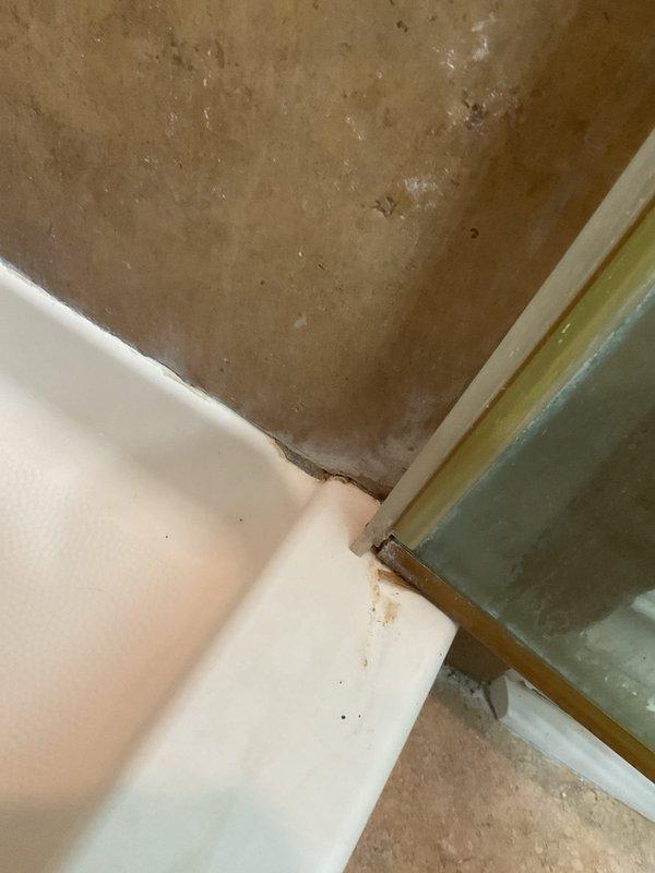Responded to water leak complaint affecting unit below from shower area. Performed visual inspection of shower basin and drain assembly to locate source of leak. Examined bathtub drain components including metallic drain assembly and surrounding basin for signs of deterioration, improper sealing, or compromised waterproofing. Inspected accessible ceiling area below shower for evidence of water intrusion and damage patterns. Documented conditions with photographs for diagnostic purposes and future reference.