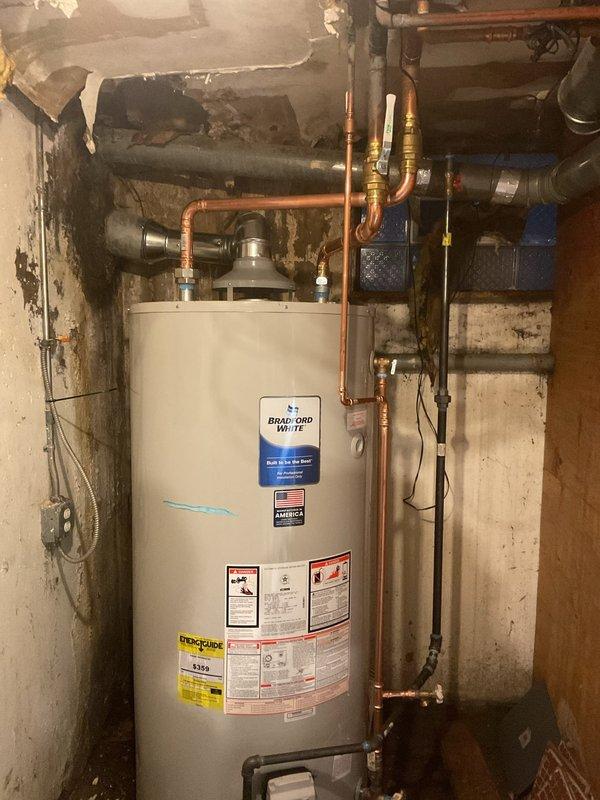Completed water heater replacement in residential basement utility room. Removed existing unit and installed new Bradford White water heater with proper copper piping connections, gas control valve assembly, and all required safety components. Ensured proper venting, configured hot and cold water supply lines, and verified all connections for leaks. System tested and operational upon completion.