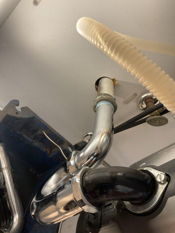 Responded to priority appointment for kitchen sink drainage issue. Upon inspection, identified failed P-trap assembly connected to garbage disposal unit requiring replacement. Removed deteriorated chrome P-trap and associated fittings from disposal outlet. Installed new P-trap assembly with proper connections to garbage disposal and drain line, ensuring secure threaded fittings and proper trap seal. Verified all connections for leaks and confirmed proper drainage flow through system. Documentation photos captured before and during repair showing cabinet interior, existing plumbing configuration, and disposal unit connections.