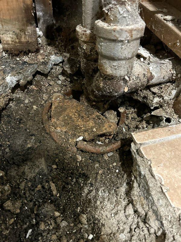 Responded to severe foundation and plumbing infrastructure damage in residential basement area. Assessed extensive water intrusion that caused structural floor failure, exposed saturated soil accumulation, and deteriorated plumbing systems including corroded metal pipes and stained PVC drainage lines. Documented compromised concrete foundation with significant cracking, mineral deposits on vertical pipe penetrations, and water-damaged wooden framing members requiring comprehensive repair and restoration work.